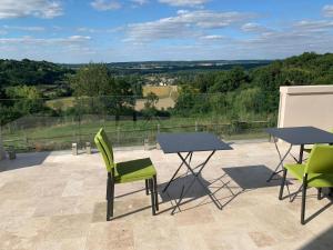 two tables and chairs on a patio with a view at Château du Mont de Guny 