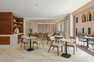 a restaurant with tables and chairs in a room at Preveza City Comfort Hotel in Preveza