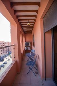 einen Balkon mit einem Tisch und Stühlen in einem Gebäude in der Unterkunft Majorelle Splendide Appartement in Marrakesch