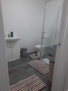 y baño con aseo, lavabo y espejo. en Double Bedroom with private bathroom and shared kitchen en Oldbury