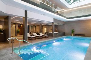 a swimming pool in a hotel with a lobby at AC Hotel by Marriott Stockholm Ulriksdal in Solna