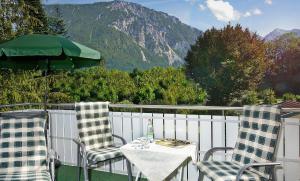 a table and chairs on a balcony with a view of a mountain at Am Badezentrum Ferienwohnungen in Ruhpolding