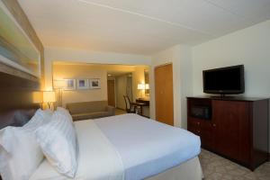 a hotel room with a bed and a flat screen tv at Holiday Inn Baltimore BWI Airport, an IHG Hotel in Linthicum Heights