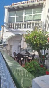 een gebouw met een patio met stoelen en een parasol bij Casa San José in Nerja