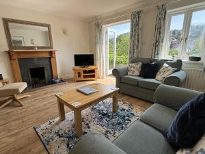 sala de estar con sofá y mesa en Primrose Cottage - South facing cottage in the heart of Dittisham, en Dittisham