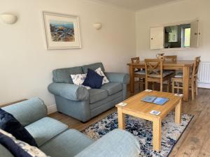 un soggiorno con un divano e un tavolo di Primrose Cottage - South facing cottage in the heart of Dittisham a Dittisham