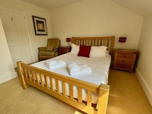 una camera da letto con un letto con due asciugamani sopra di Primrose Cottage - South facing cottage in the heart of Dittisham a Dittisham