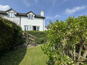 una casa bianca con recinzione e giardino di Primrose Cottage - South facing cottage in the heart of Dittisham a Dittisham