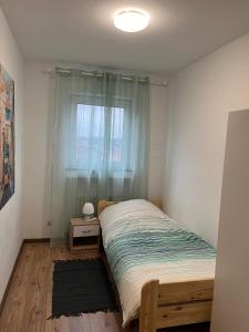 a small bedroom with a bed with a window at Bruchköbel 1 auch für Monteure in Bruchköbel