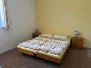 a bed in a room with two nightstands and a bed sidx sidx sidx at Pension Palla in Svojanov