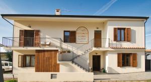 a white house with a staircase in front of it at Dommu Livia in Lotzorai