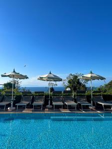 a swimming pool with chairs and umbrellas at Resort Terme La Pergola in Casamicciola Terme