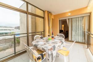 Un comedor con mesa y sillas y un balcón. en Apartamento completo con piscina y amplio balcón, en Cunit