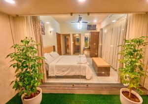 a bedroom with a bed and two potted plants at Glen Castle Vagamon Pool Resort by VOYE HOMES in Vagamon