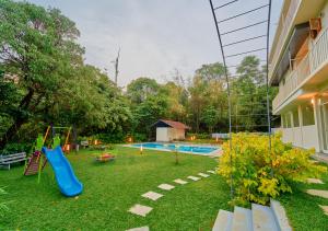 a backyard with a playground with a slide at Glen Castle Vagamon Pool Resort by VOYE HOMES in Vagamon +101 photos