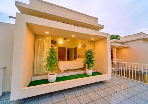 a bedroom with two potted plants on a balcony at Glen Castle Vagamon Pool Resort by VOYE HOMES in Vagamon
