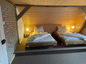 ヴァルメンシュタイナハにあるFerienhaus Lindeの木造キャビン内のベッド2台が備わる部屋