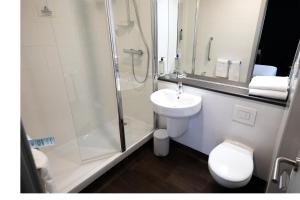 Un baño con ducha, lavabo e inodoro. en Travelodge Madrid Metropolitano, en Madrid