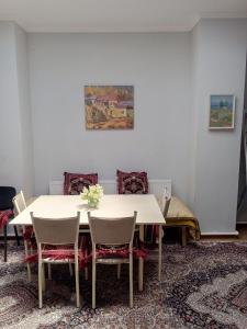 uma sala de jantar com uma mesa branca e cadeiras em Rassom Hostel em Samarkand