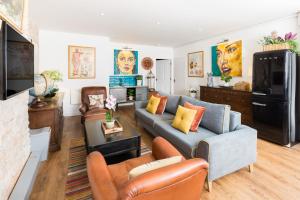 GloucestershireにあるQueens Head Apartmentsのソファとテレビのあるリビングルーム
