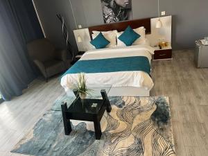 1 dormitorio con 1 cama con mesa de cristal y sofá en Sôsuite en Saly Portudal