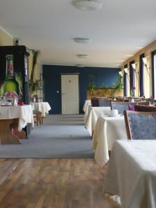 una sala da pranzo con tavoli bianchi e una porta bianca di Landgasthaus Fecht ad Aurich