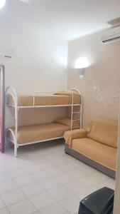 a room with two bunk beds and a couch at One bedroom apartement with shared pool terrace and wifi at Sciacca in Sciacca