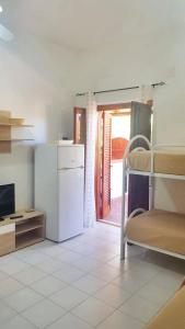 a room with a white refrigerator and a kitchen at One bedroom apartement with shared pool terrace and wifi at Sciacca in Sciacca