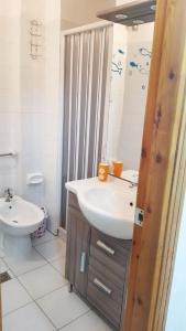 a bathroom with a white sink and a toilet at One bedroom apartement with shared pool terrace and wifi at Sciacca in Sciacca