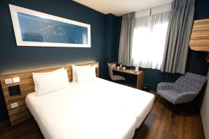 una habitación de hotel con una cama y una silla en Travelodge Madrid Metropolitano, en Madrid 31 fotos más