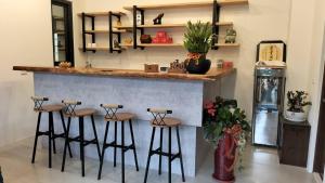 a kitchen with a counter with stools at a bar at Liangchen B&B in Fanlu