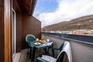 una mesa y sillas en un balcón con vistas en Résidence Pierre & Vacances Les Trois Domaines en Ax-les-Thermes