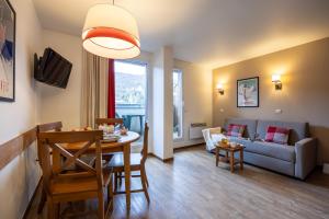 a living room with a table and a couch at Résidence Pierre & Vacances Les Trois Domaines in Ax-les-Thermes
