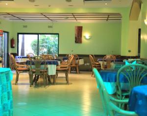 a dining room with tables and chairs and blue tables and chairs at ACK Guest House Nairobi in Nairobi