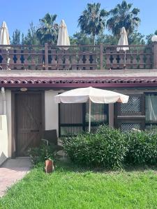 an umbrella sitting in the grass in front of a house at Hotel Berke Ranch&Nature in Kemer