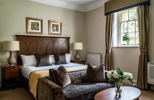 pokój hotelowy z łóżkiem i kanapą w obiekcie Crathorne Hall w mieście Yarm