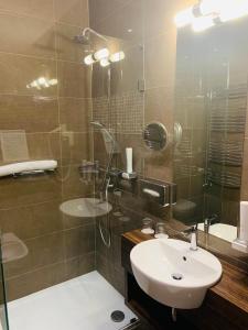 a bathroom with a sink and a glass shower at Barack Thermal Hotel and Spa in Tiszakécske