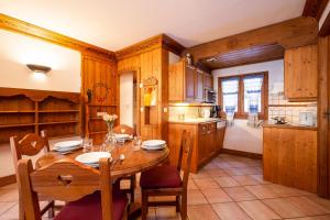 eine Küche mit einem Holztisch sowie einem Tisch und Stühlen in der Unterkunft Résidence Le Cristal - Grands Montets 8 - Happy Rentals in Chamonix-Mont-Blanc