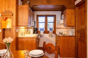 eine Küche mit Holzschränken und einem Tisch mit Tellern in der Unterkunft Résidence Le Cristal - Grands Montets 8 - Happy Rentals in Chamonix-Mont-Blanc