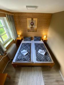 2 Betten in einem kleinen Zimmer mit 2 Fenstern in der Unterkunft Hotel Pod Sokolím in Terchová