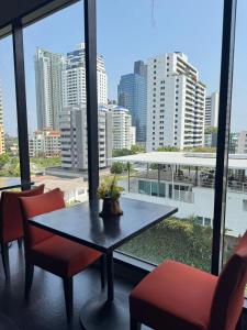 a table and chairs in a room with a view of a city at Metacity Bangkok in Bangkok
