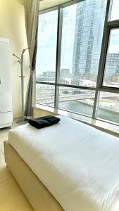 a large bed in a room with a large window at Wonderful two bed room with full marina view in Dubai