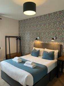 1 dormitorio con 1 cama grande y toallas. en The Wheatsheaf Inn en Ingleton 