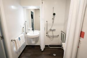 biała łazienka z umywalką i prysznicem w obiekcie Travelodge Madrid Metropolitano w Madrycie