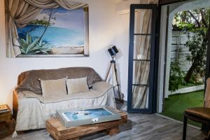 - un salon avec un canapé et une table dans l'établissement Les Canoubiers Luxe et sérénité au cœur de Saint-Tropez Suites spacieuses avec jardin enchanteur, à Saint-Tropez
