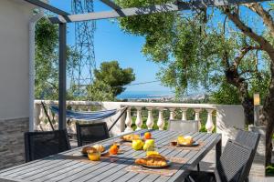 ニースにあるVilla vue mer, terrasse et spaの木製テーブル(食べ物付)が備わるパティオ
