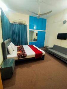 ein Schlafzimmer mit einem Bett und einem Sofa in einem Zimmer in der Unterkunft Peridot Cottage in Islamabad