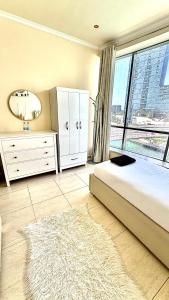 a bedroom with a bed and a large window at Wonderful two bed room with full marina view in Dubai