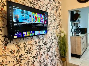 uma televisão de ecrã plano pendurada numa parede em 435 on vale boutique aparthotel em Joanesburgo