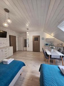 a room with two beds and a table and a kitchen at Pokoje Gościnne Pod Lipami in Kudowa-Zdrój